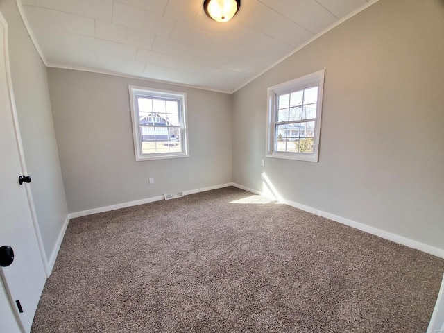 carpeted spare room featuring visible vents, ornamental molding, and baseboards