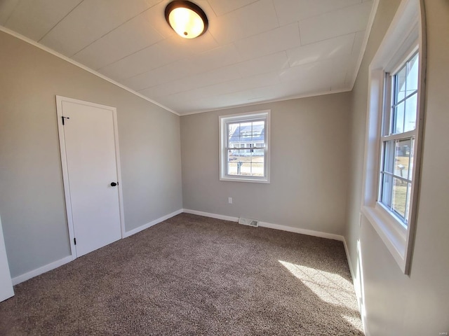 spare room featuring carpet, vaulted ceiling, crown molding, and baseboards