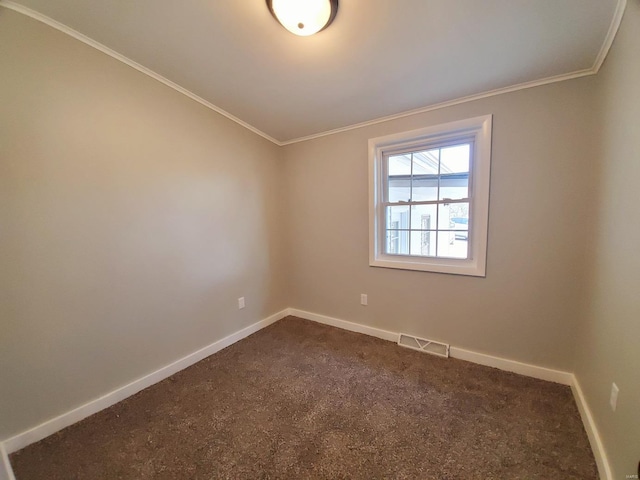 spare room featuring ornamental molding, dark carpet, visible vents, and baseboards