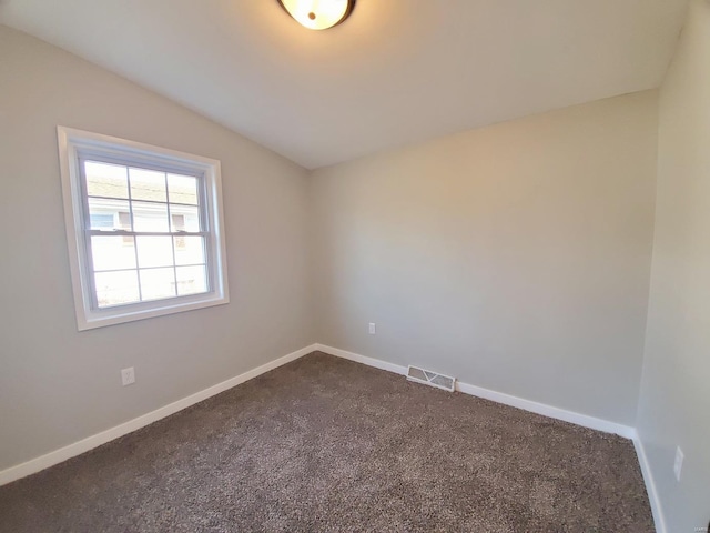 unfurnished room featuring lofted ceiling, visible vents, and baseboards