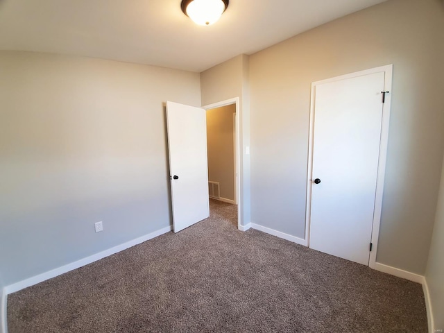 unfurnished bedroom featuring carpet floors, baseboards, and visible vents