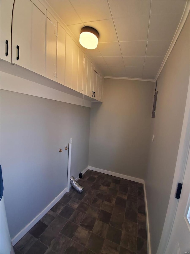 washroom featuring cabinet space, baseboards, and crown molding