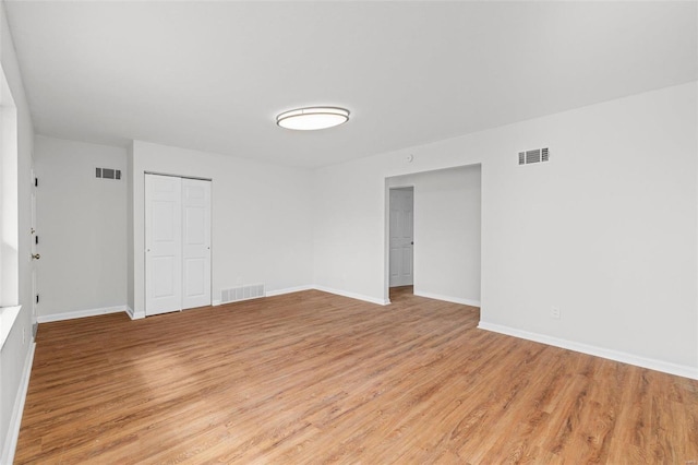 unfurnished room with light wood-style floors, baseboards, and visible vents