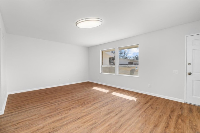 spare room featuring light wood-style flooring and baseboards