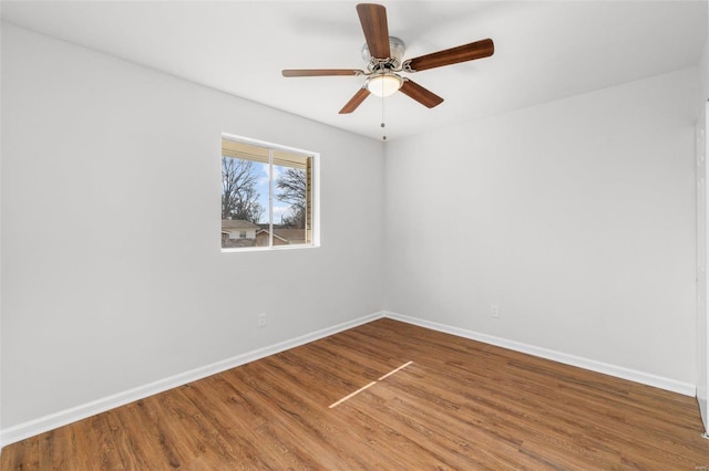 spare room with a ceiling fan, baseboards, and wood finished floors