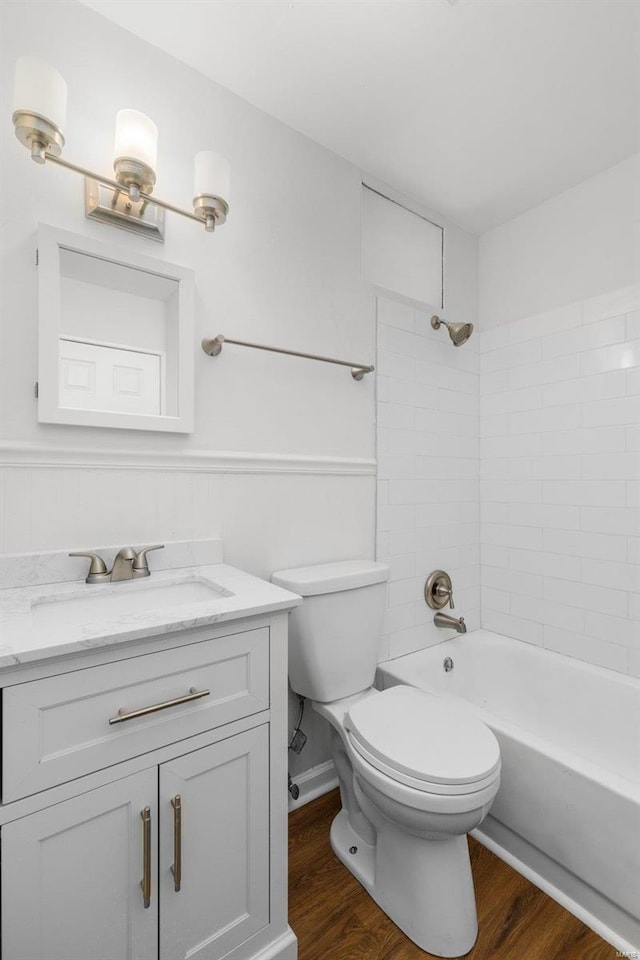 full bath with toilet, a wainscoted wall, wood finished floors, and vanity