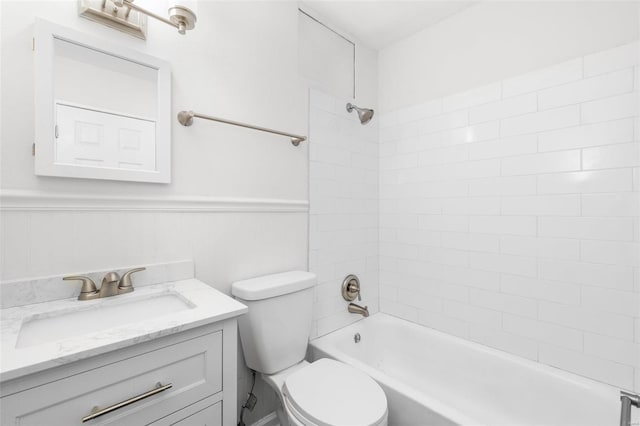 full bath with a wainscoted wall, shower / tub combination, vanity, and toilet