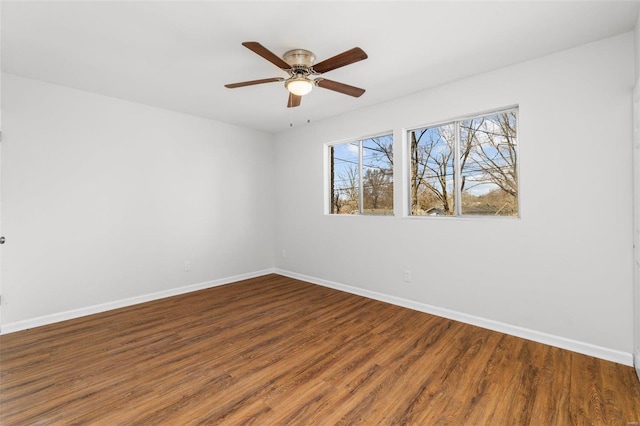 empty room with a ceiling fan, baseboards, and wood finished floors