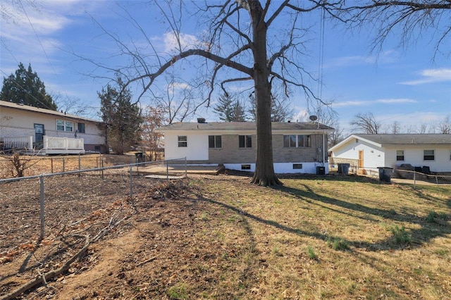 back of house with crawl space, a fenced backyard, and a lawn