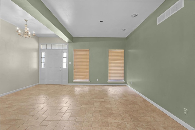 foyer entrance featuring a chandelier, visible vents, and baseboards