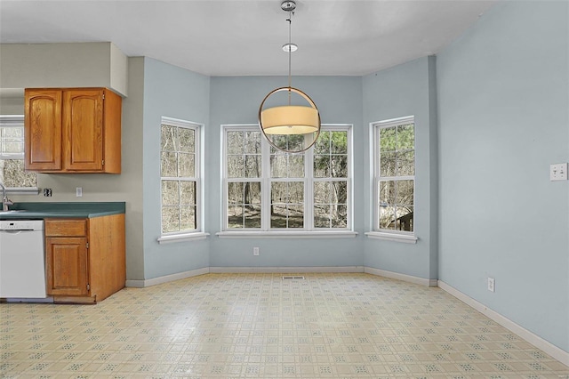 unfurnished dining area with baseboards, plenty of natural light, and light floors