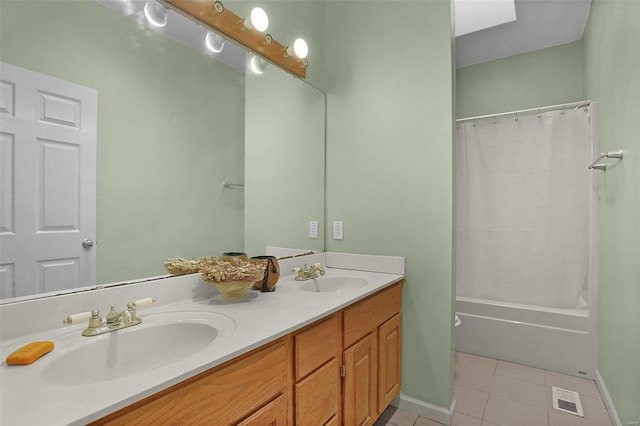 bathroom with tile patterned flooring, double vanity, visible vents, and a sink