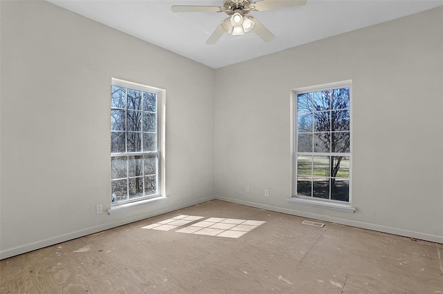 unfurnished room featuring a ceiling fan, visible vents, and baseboards