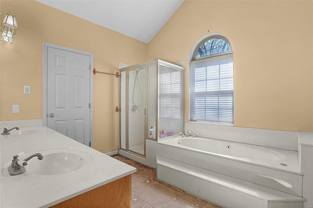 bathroom featuring a sink, a stall shower, a garden tub, and vaulted ceiling