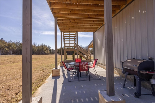 view of patio / terrace featuring outdoor dining area, stairway, and grilling area