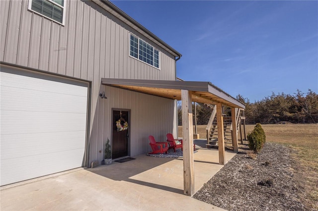 view of patio / terrace featuring a garage and stairway