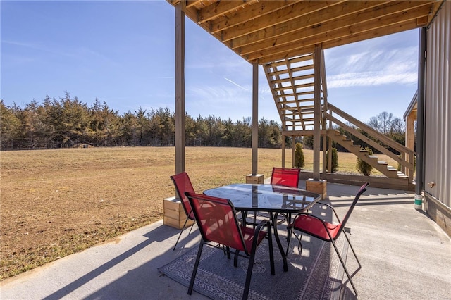 view of patio featuring outdoor dining area and stairway