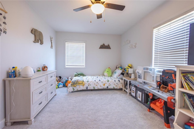 bedroom featuring light carpet and a ceiling fan