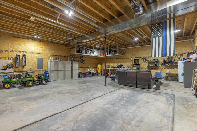 garage featuring a garage door opener, electric panel, and a workshop area