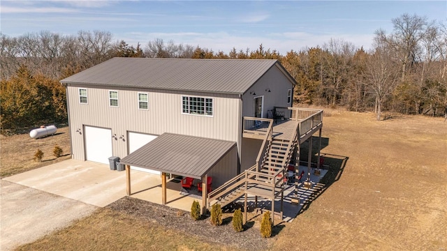 view of front of house featuring a deck, metal roof, driveway, and stairway