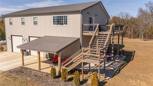 view of front of property with metal roof, an attached garage, driveway, stairway, and a wooden deck