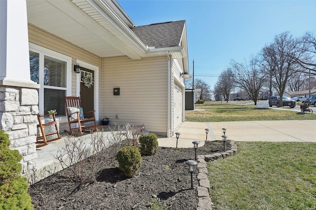 exterior space with covered porch, an attached garage, and concrete driveway