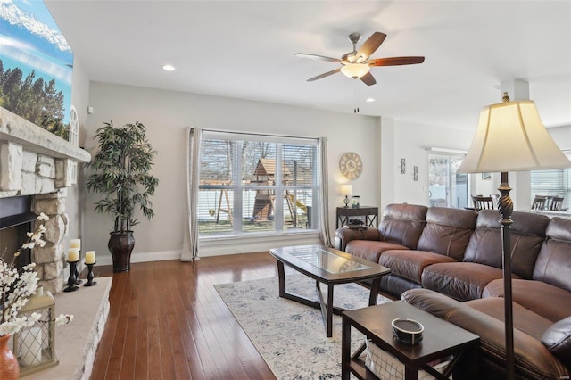 living room featuring a ceiling fan, baseboards, recessed lighting, a fireplace, and hardwood / wood-style flooring