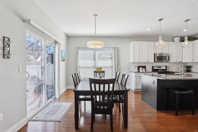 dining area with baseboards and dark wood-style floors