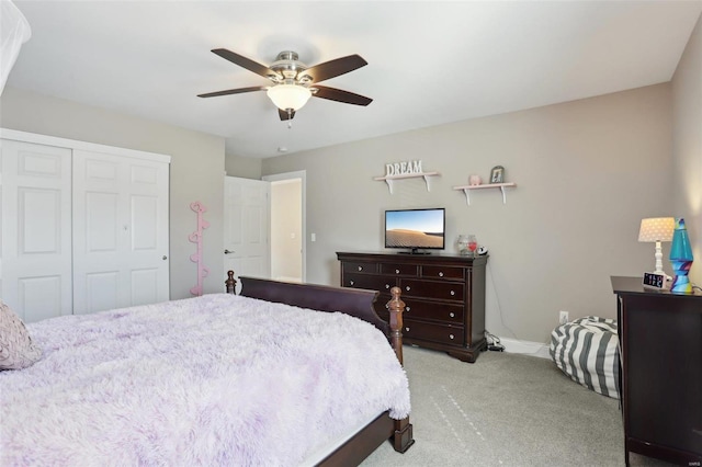 carpeted bedroom featuring a closet, baseboards, and a ceiling fan