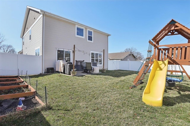 back of house with a patio, a fenced backyard, a playground, a yard, and a garden