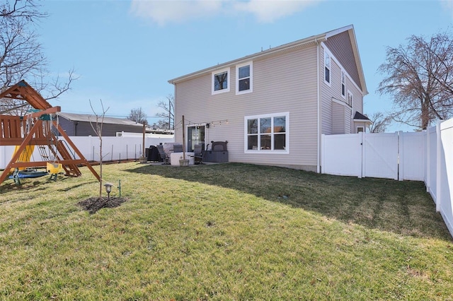 back of property with a yard, a playground, and a fenced backyard