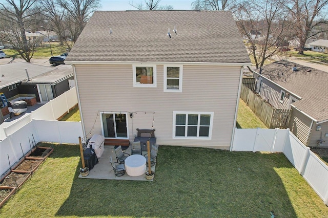 back of property with a shingled roof, a lawn, a fenced backyard, a patio area, and a gate