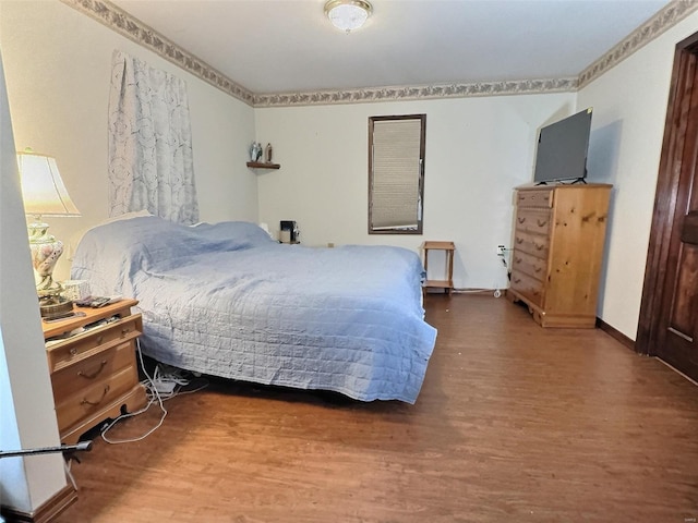 bedroom featuring baseboards and wood finished floors