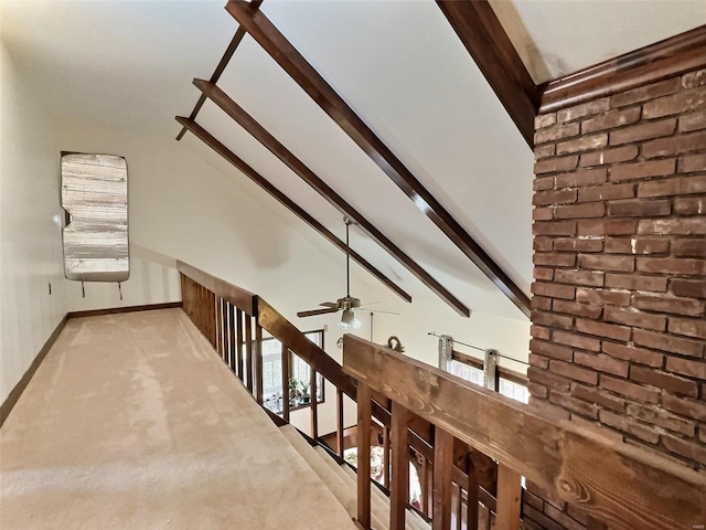 interior space featuring lofted ceiling with beams, light carpet, a wealth of natural light, and baseboards