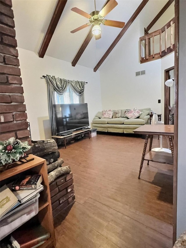 living area featuring visible vents, ceiling fan, wood finished floors, high vaulted ceiling, and beamed ceiling