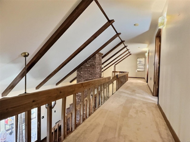 hall featuring vaulted ceiling with beams, light carpet, and baseboards