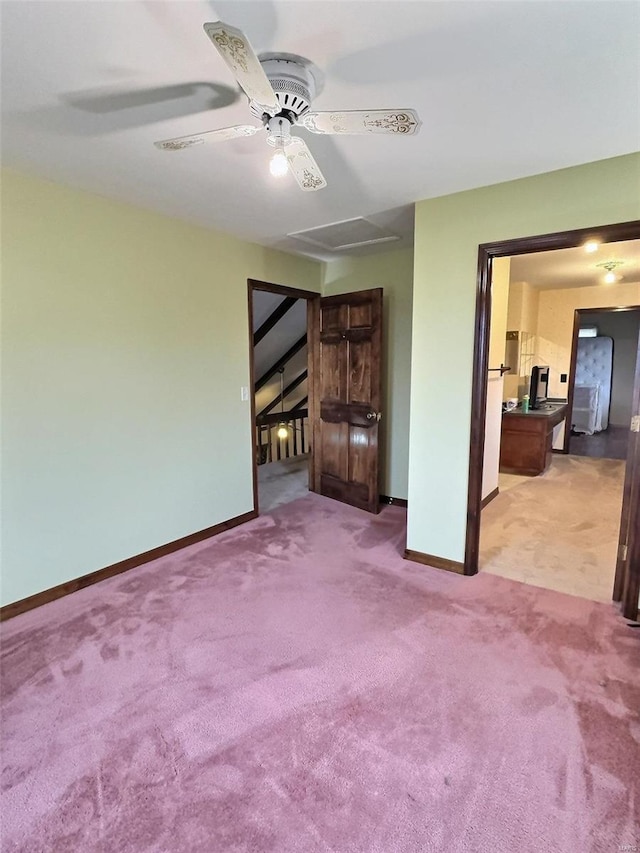 carpeted empty room featuring visible vents, attic access, and baseboards