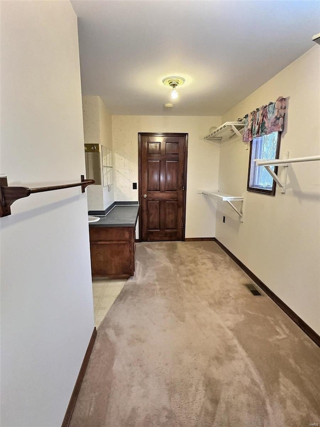 interior space featuring visible vents, baseboards, and light colored carpet