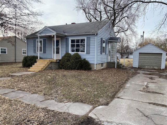 bungalow-style house with a garage, driveway, roof with shingles, and an outbuilding