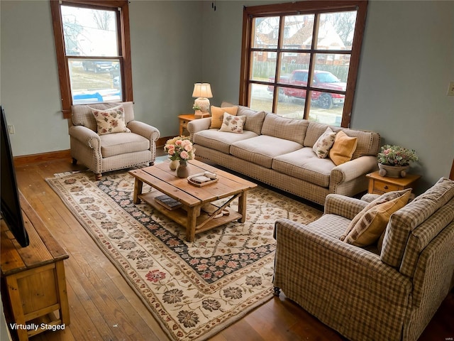 living area with a wealth of natural light, baseboards, and hardwood / wood-style floors