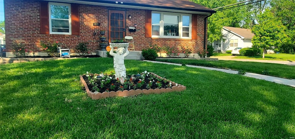 view of front of property with brick siding and a front yard