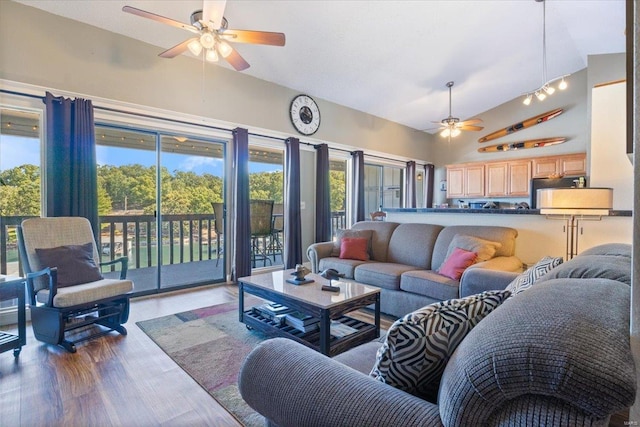 living area featuring a ceiling fan, high vaulted ceiling, and wood finished floors