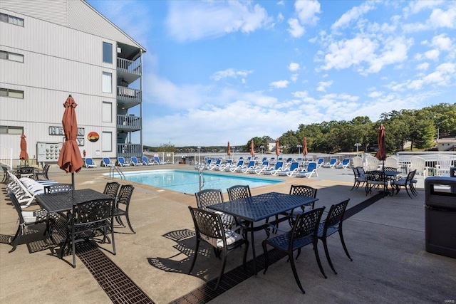 community pool with outdoor dining space and a patio