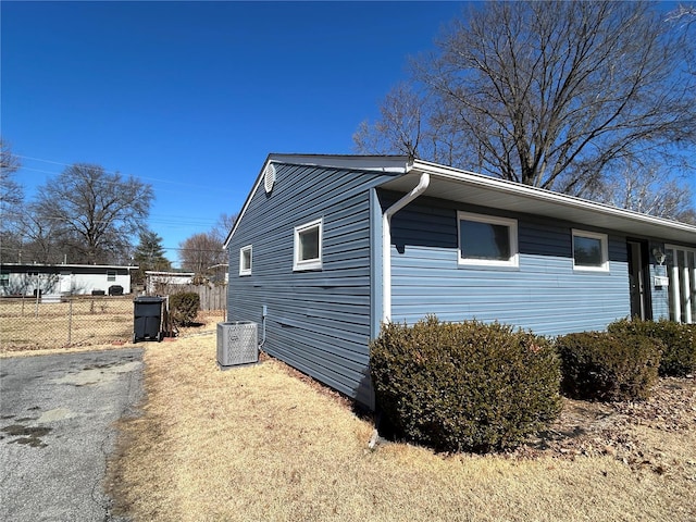 view of side of property with fence and cooling unit