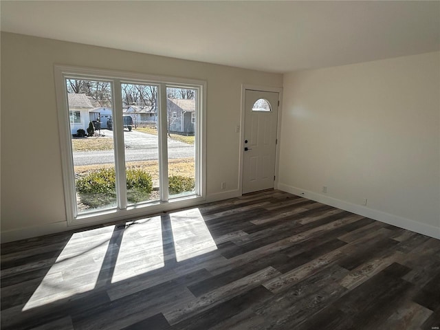 entryway with dark wood-style floors, plenty of natural light, and baseboards