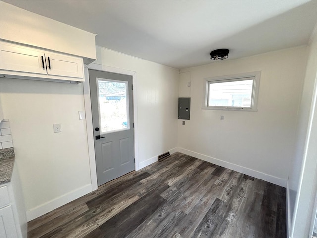 entryway with dark wood-style flooring, electric panel, and baseboards