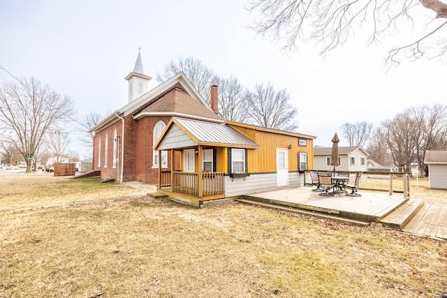 back of property with brick siding, a chimney, and a wooden deck