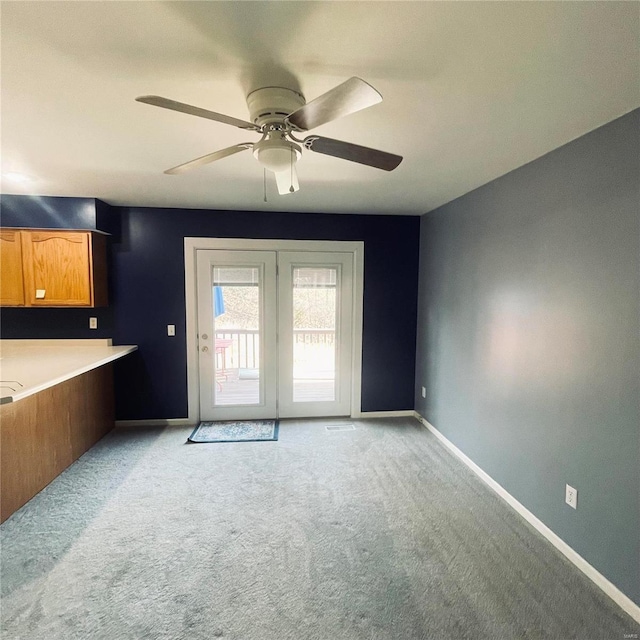 doorway to outside featuring baseboards, ceiling fan, and light colored carpet