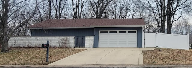 garage featuring driveway and fence