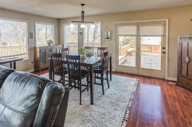 dining space with a wealth of natural light, baseboards, and wood finished floors